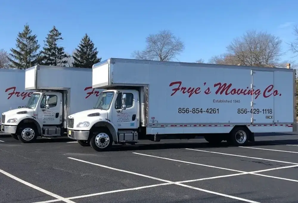 Frye's Moving Co. trucks line up parked in an empty parking lot.
