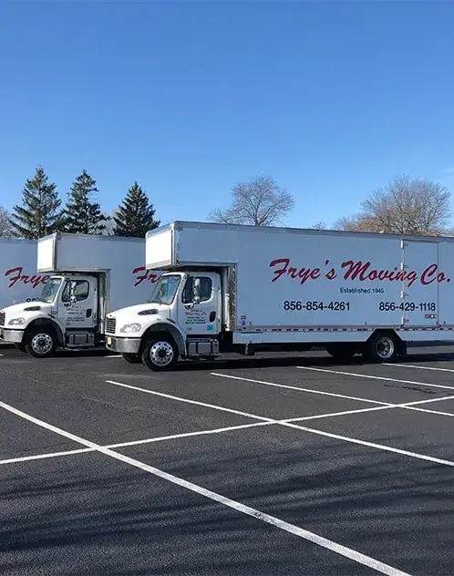 Three Frye's Moving Company trucks in parking lot.