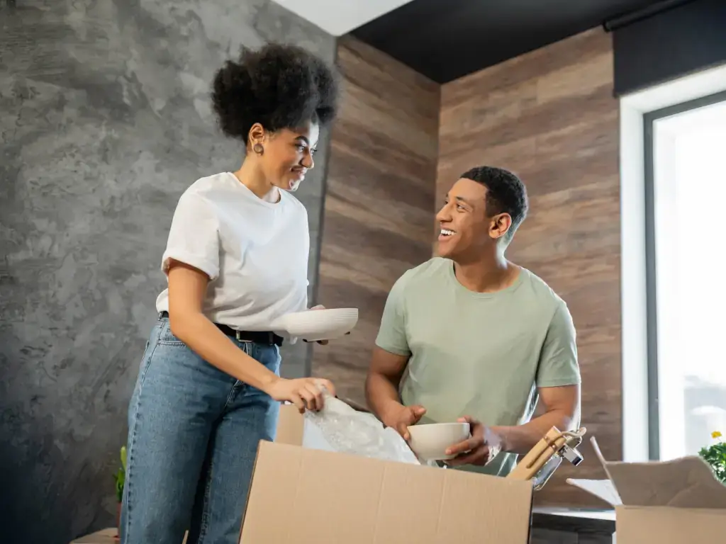 Happy couple unpacking boxes Happy couple in new home unpacking boxes