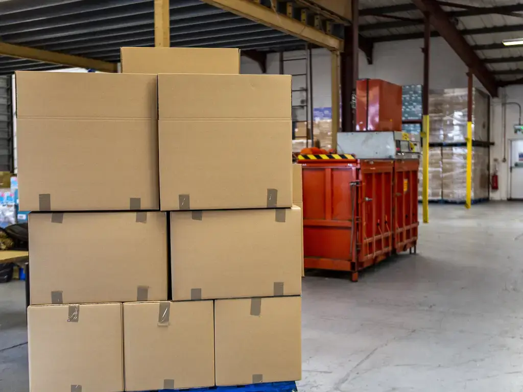 Commercial Moving Commercial moving in progress with stacked boxes inside warehouse building.