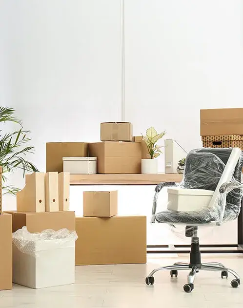 Office relocation with moving boxes and wrapped chair.
