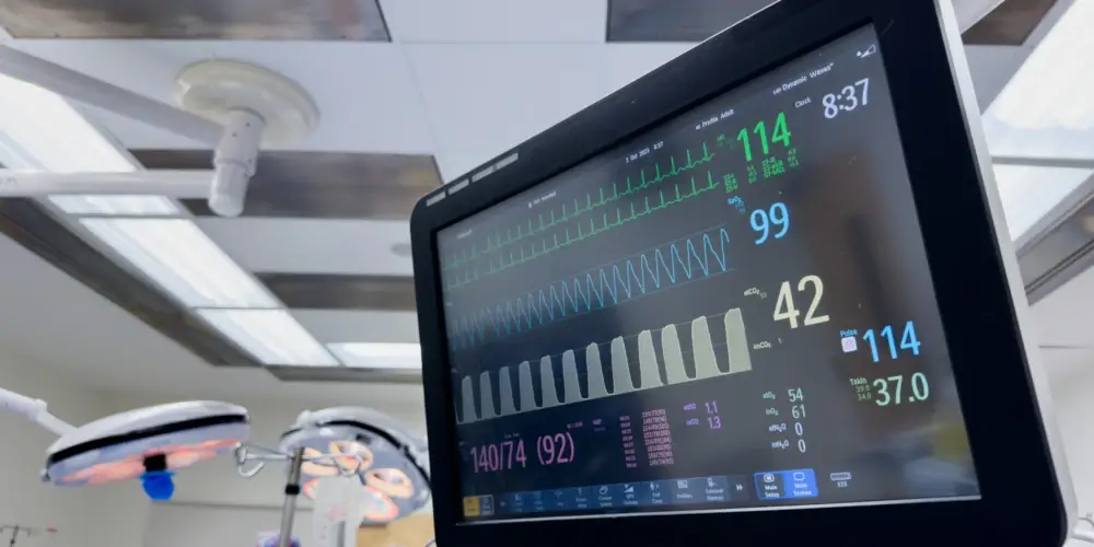 Vital signs monitor displaying data in a hospital room.