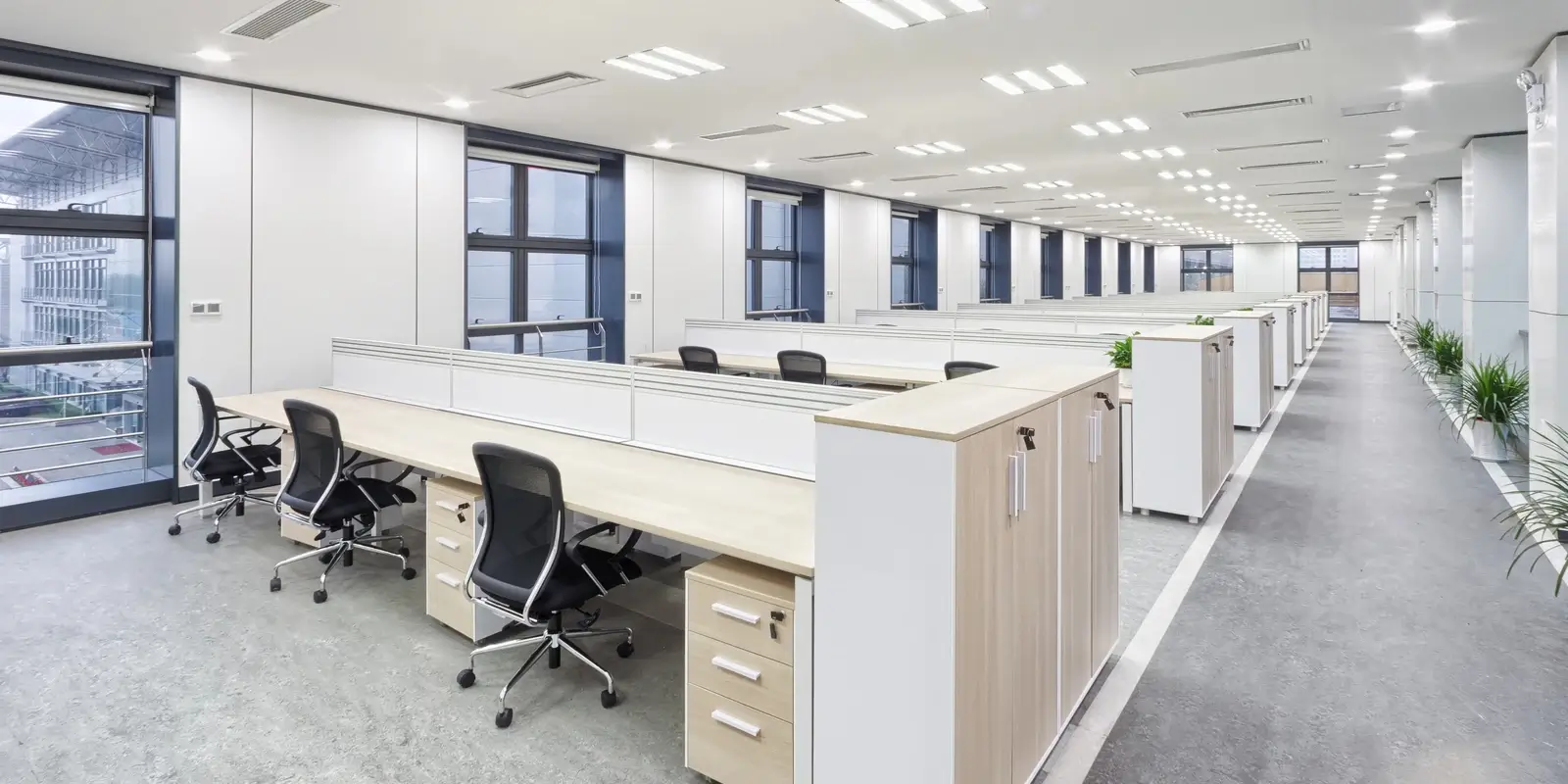 Modern office interior with desks and panoramic windows.
