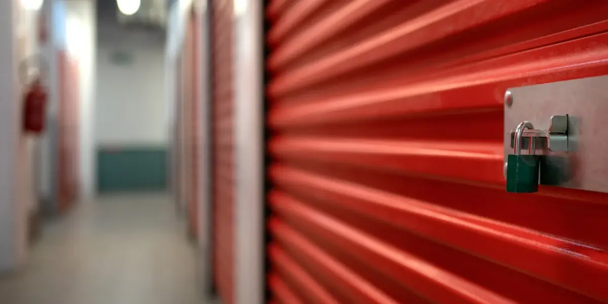 Red storage locker with secured padlock in corridor.